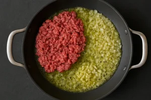 Ground beef cooking with onions and garlic for creamy beef and garlic butter pasta