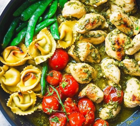 Pesto Chicken Tortellini with Asparagus in a skillet"