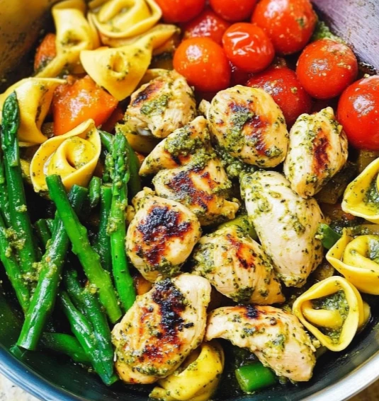 Pesto Chicken with Tortellini and sautéed vegetables served on a summer plate