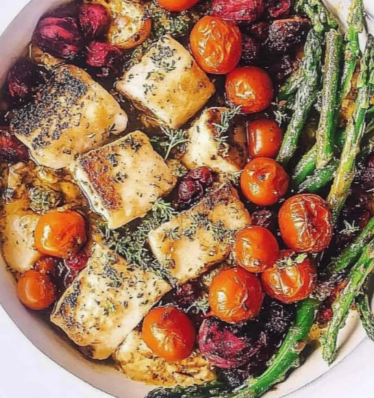 Spring dinner chicken ravioli with pesto and vegetables served on a white plate